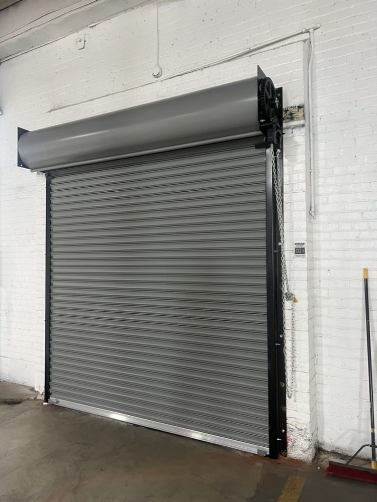 Gray rolling steel commercial shutter door installation
